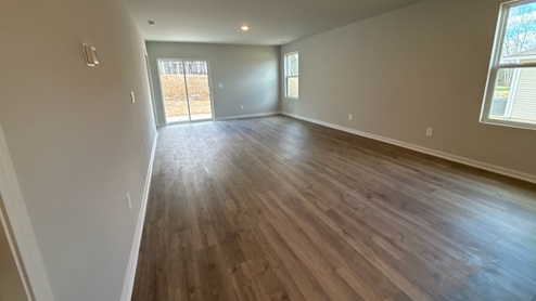 Living room in new, open-concept home with windows and natural lighting