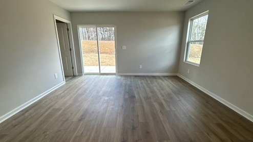 Living room in new, open-concept home with windows and natural lighting