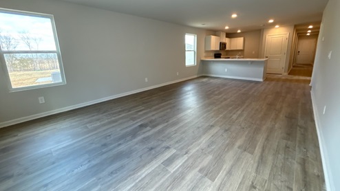 Living room in new, open-concept home with windows and natural lighting