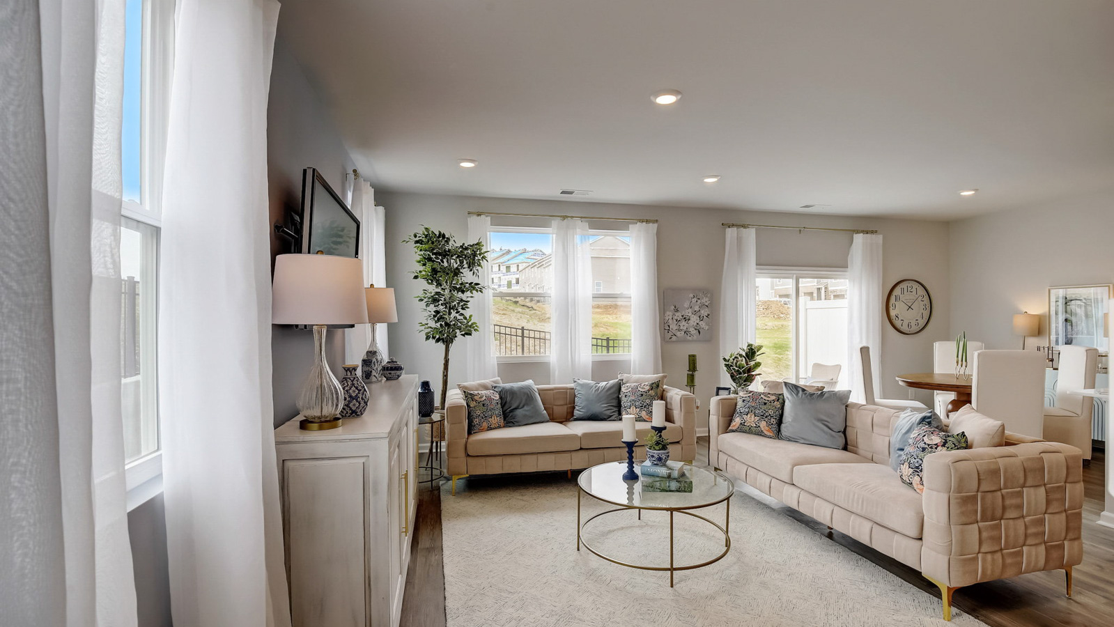 Living room in new, open-concept home with windows and natural lighting