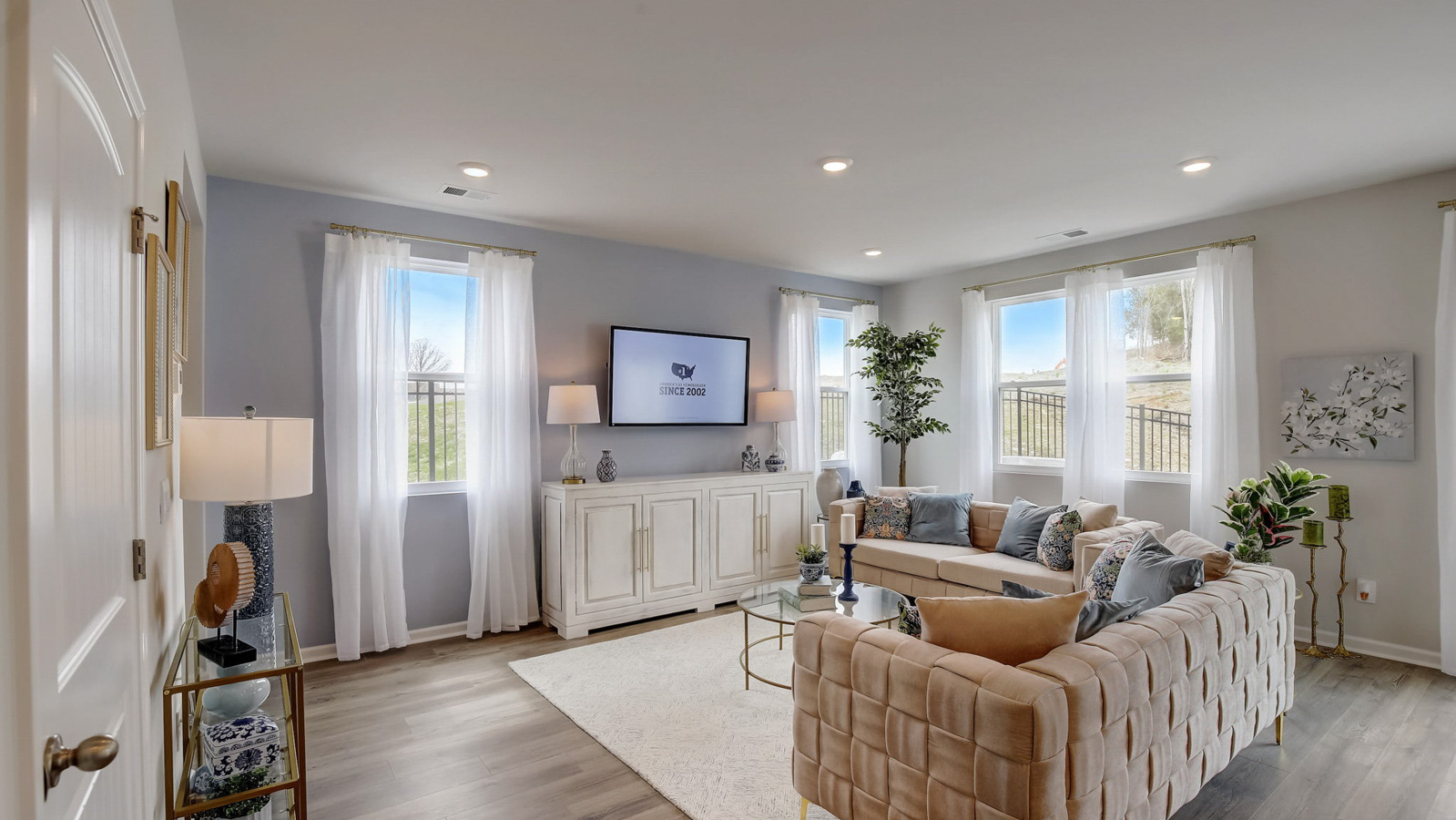 Living room in new, open-concept home with windows and natural lighting