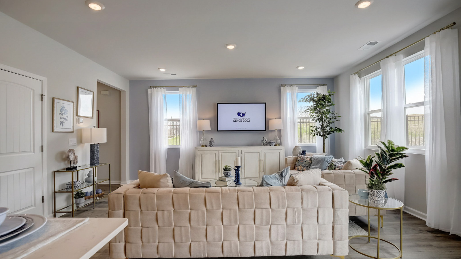 Living room in new, open-concept home with windows and natural lighting