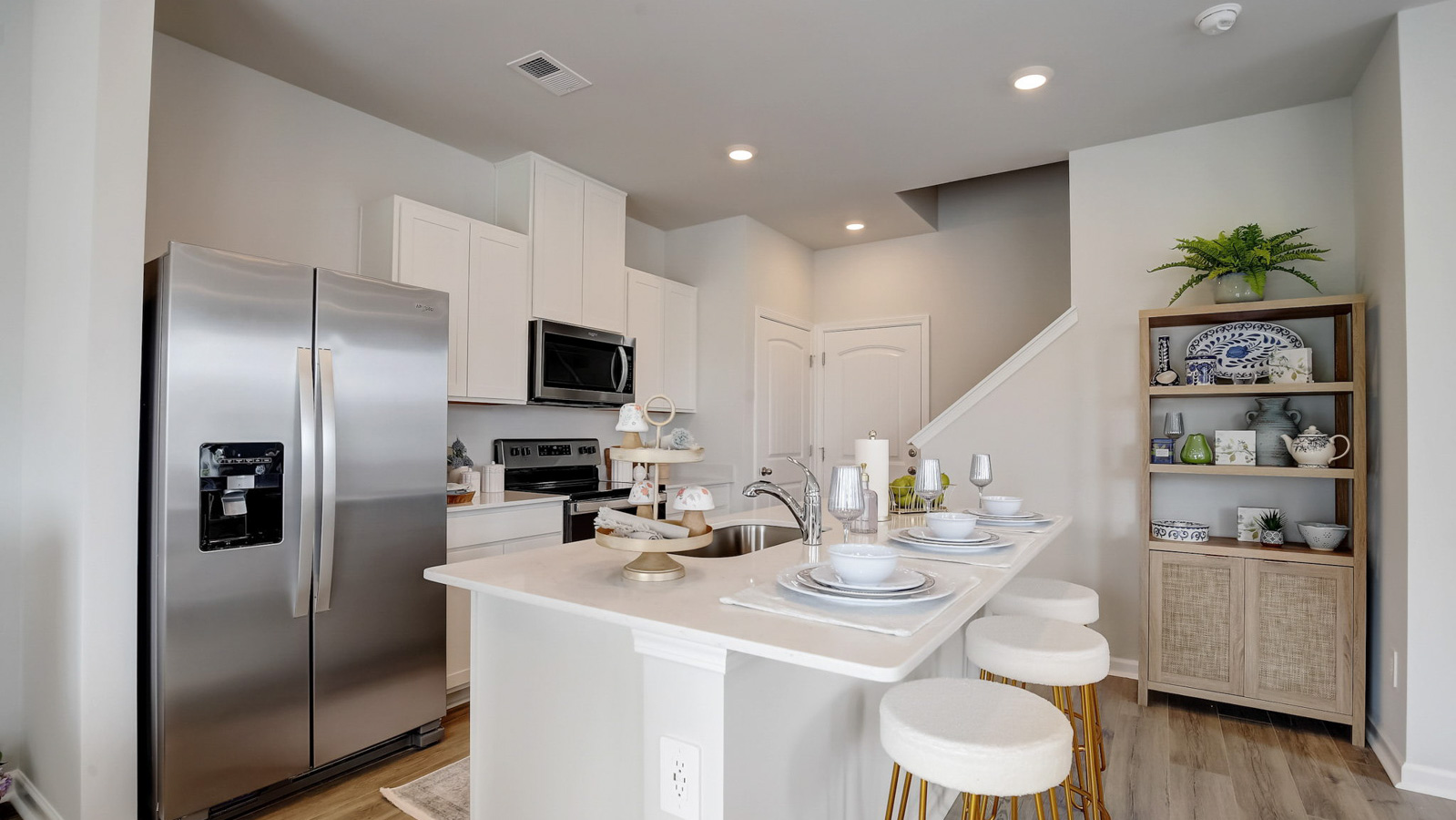 Kitchen peninsula with white cabinets and stainless steel appliances.