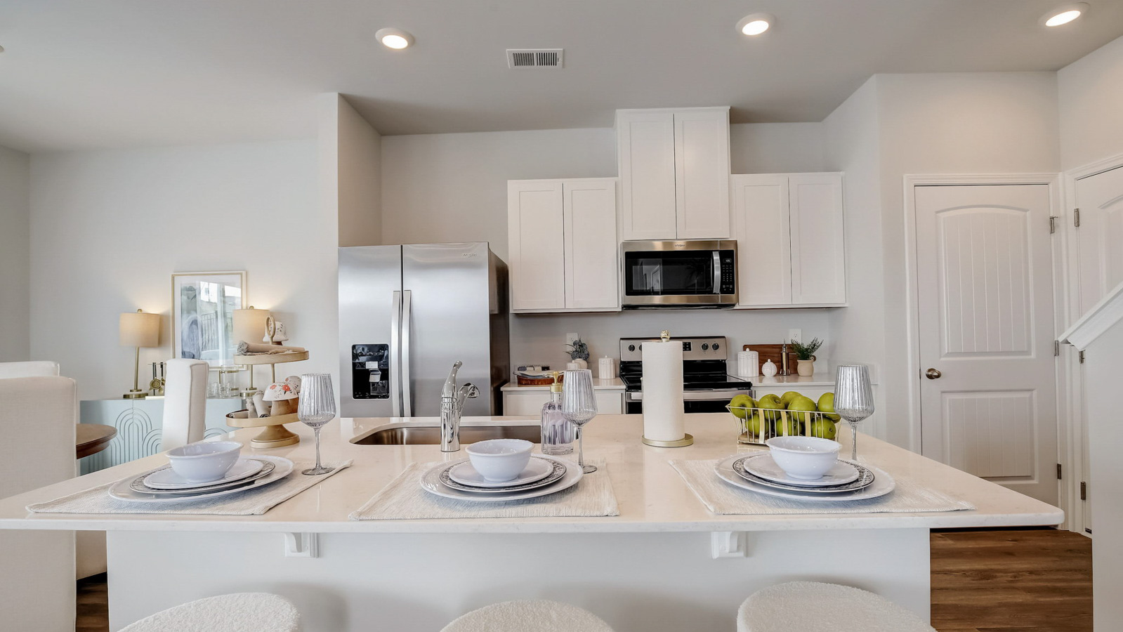 Kitchen peninsula with white cabinets and stainless steel appliances.
