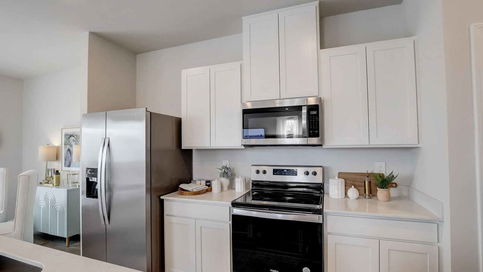Kitchen peninsula with white cabinets and stainless steel appliances.