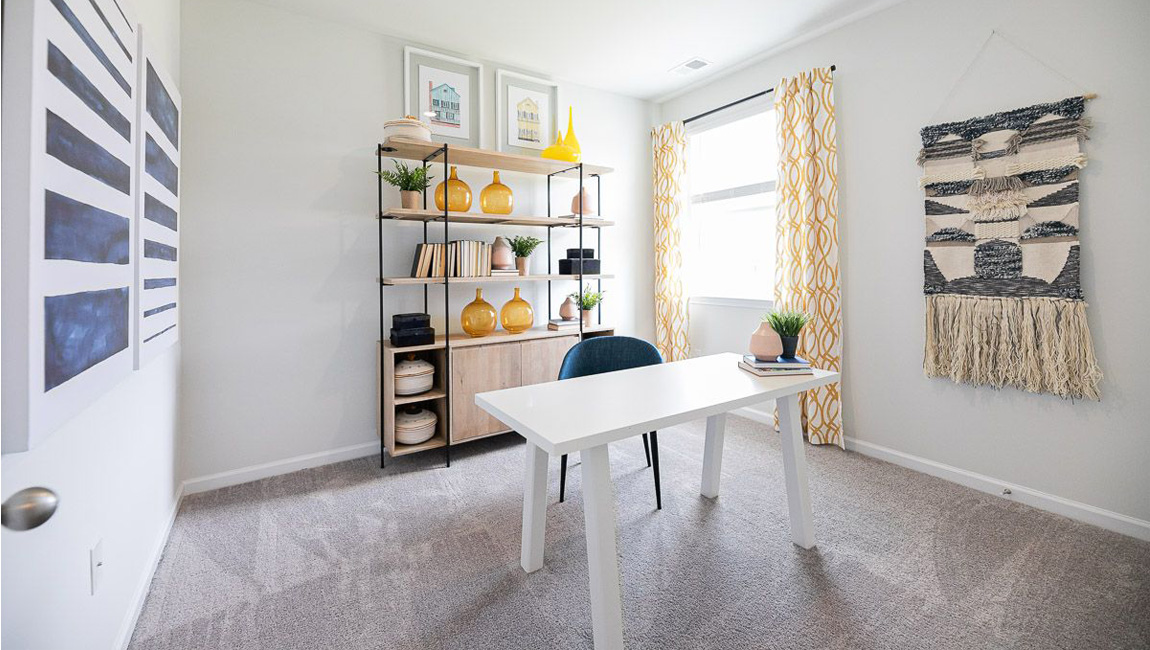Office space with neutral carpet, natural light, and simple decor.