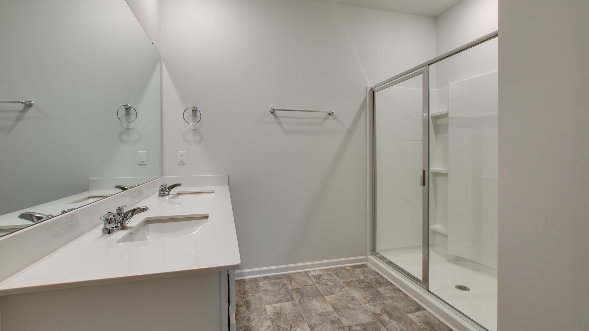 Bathroom with dual sinks and a wide mirror.