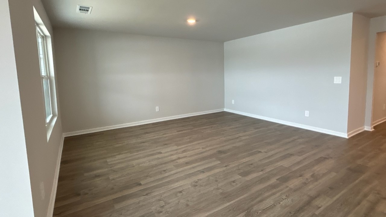 Living room in new, open-concept home with windows and natural lighting