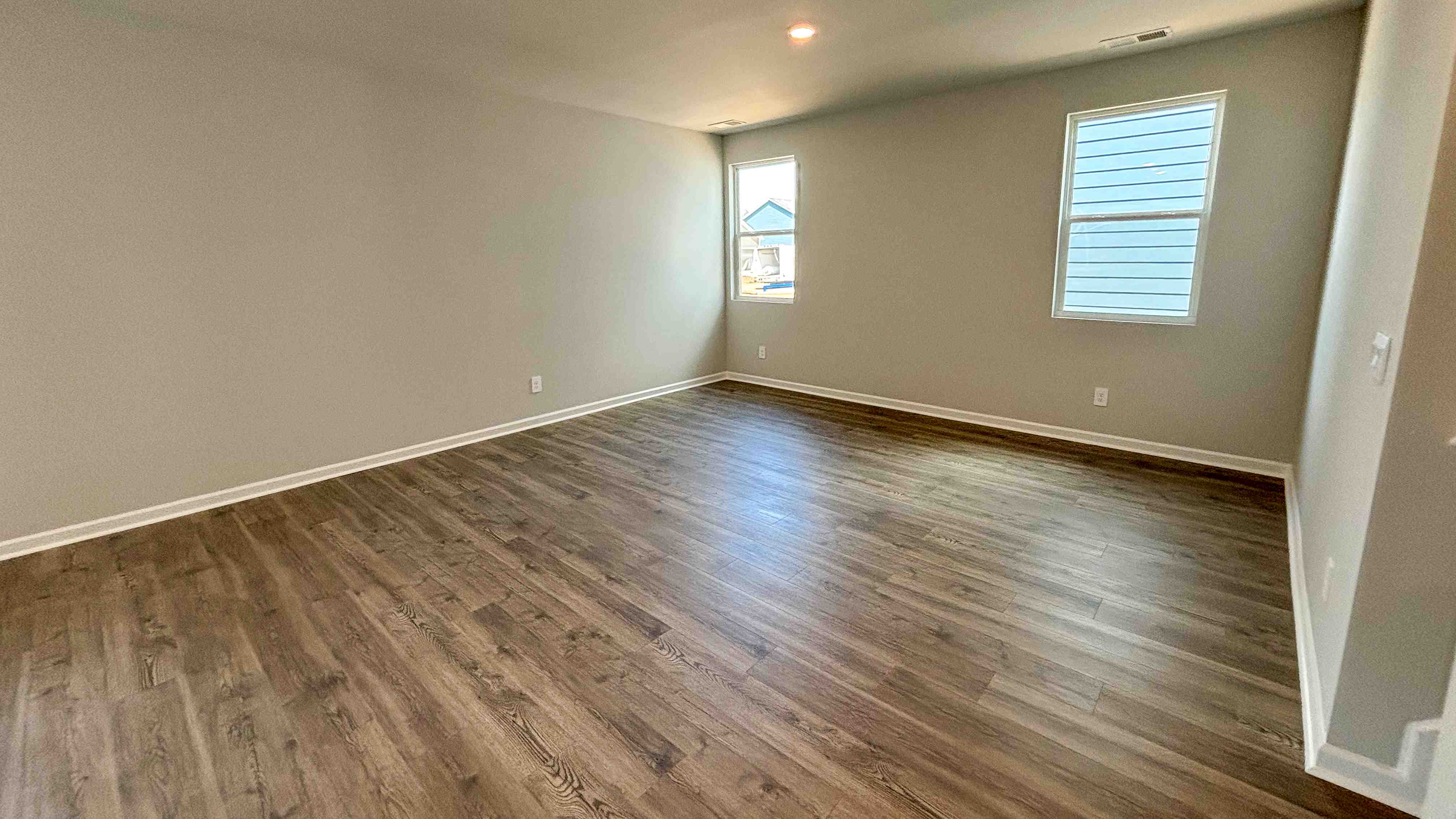 Living room in new, open-concept home with windows and natural lighting