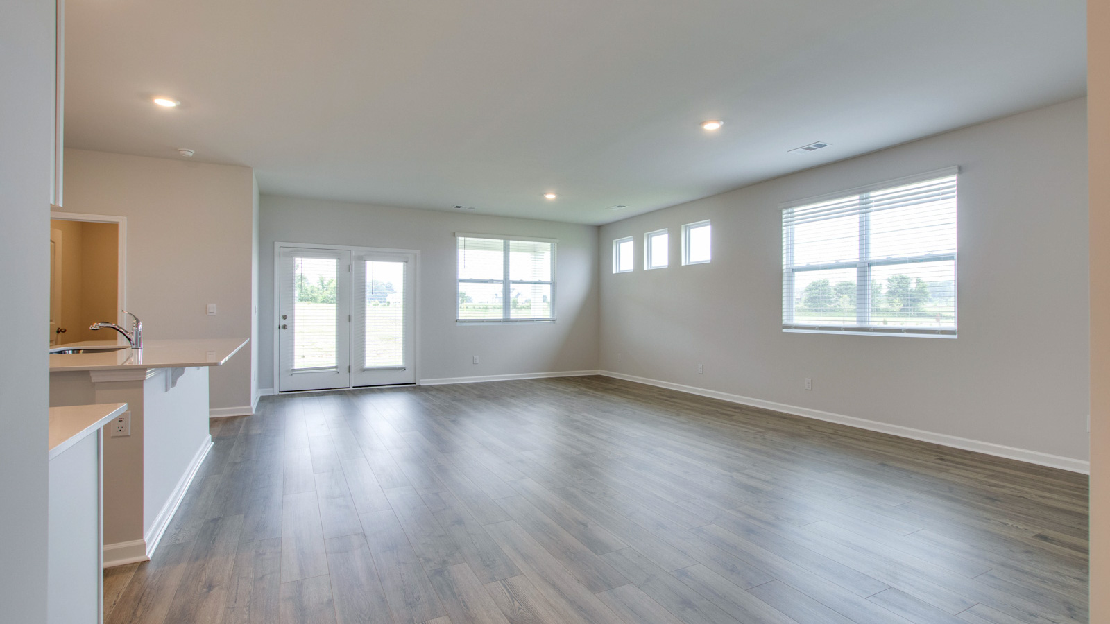Living room in new, open-concept home with windows and natural lighting