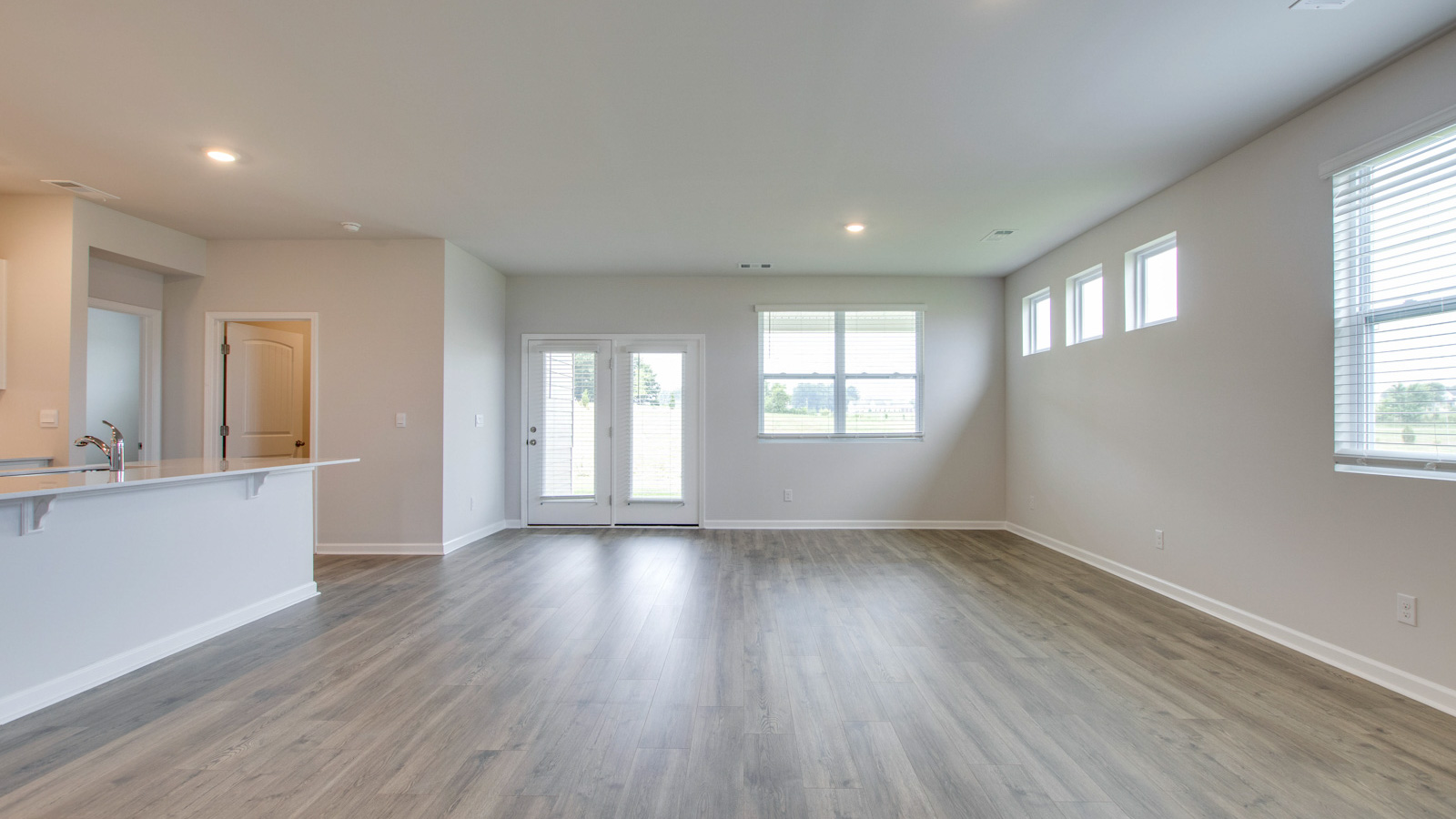 Living room in new, open-concept home with windows and natural lighting