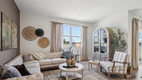 Living room in new, open-concept home with windows and natural lighting
