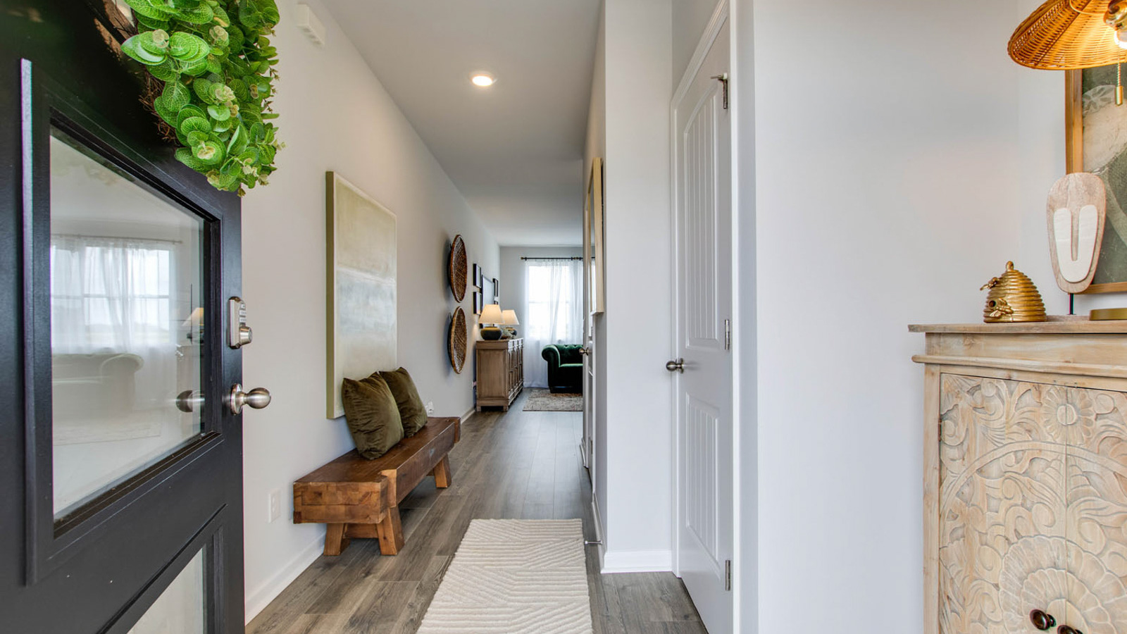 front entry way of home featuring brown flooring and white walls
