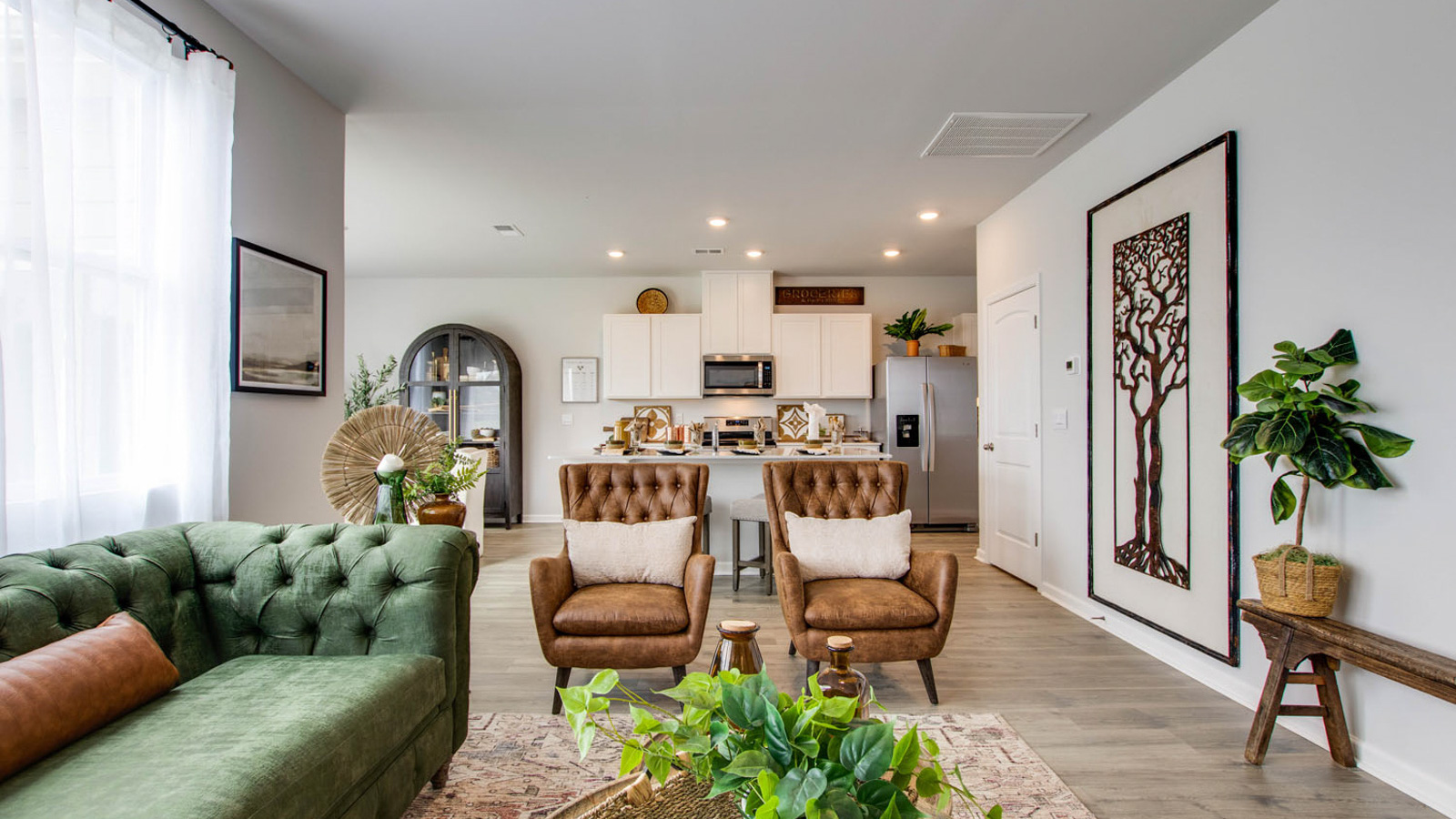 Spacious living room with brown flooring, white walls and windows