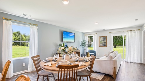 Dining room in new, open-concept home with windows and natural lighting