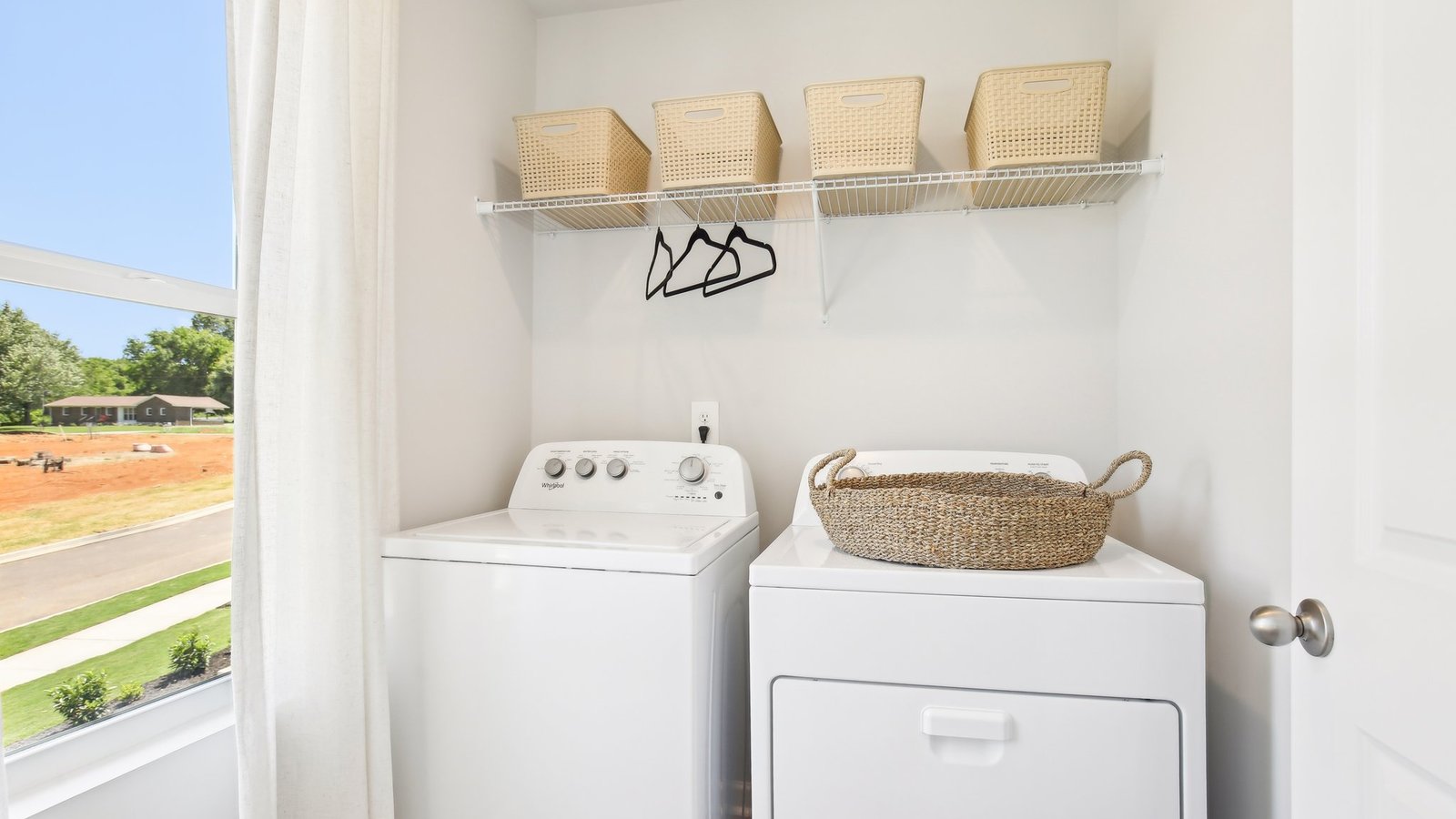 Parkside Point laundry room with new washer, dryer included, crafty overhead shelving designed by D.R. Horton