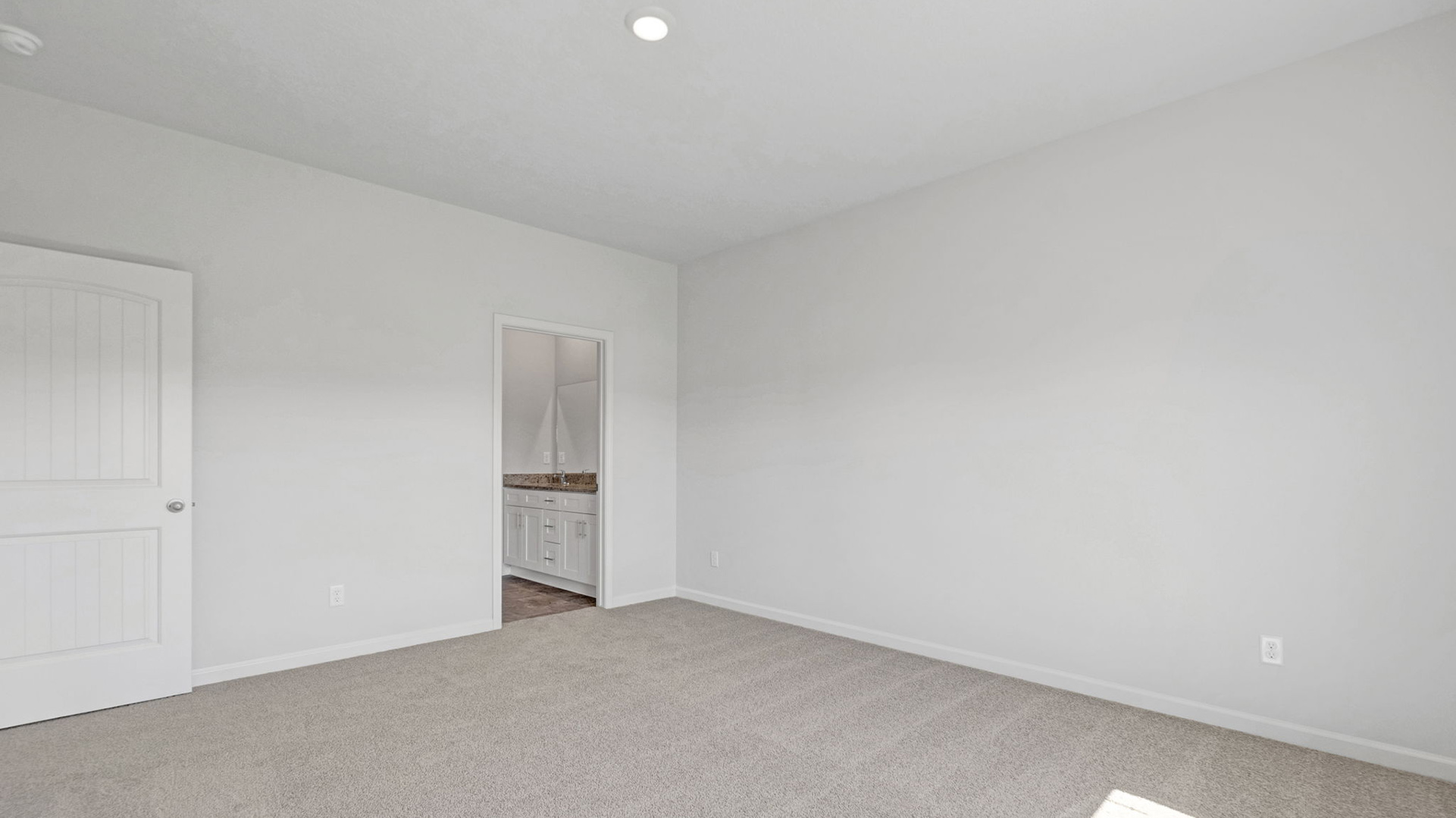 Primary bedroom with carpet flooring and neutral paint