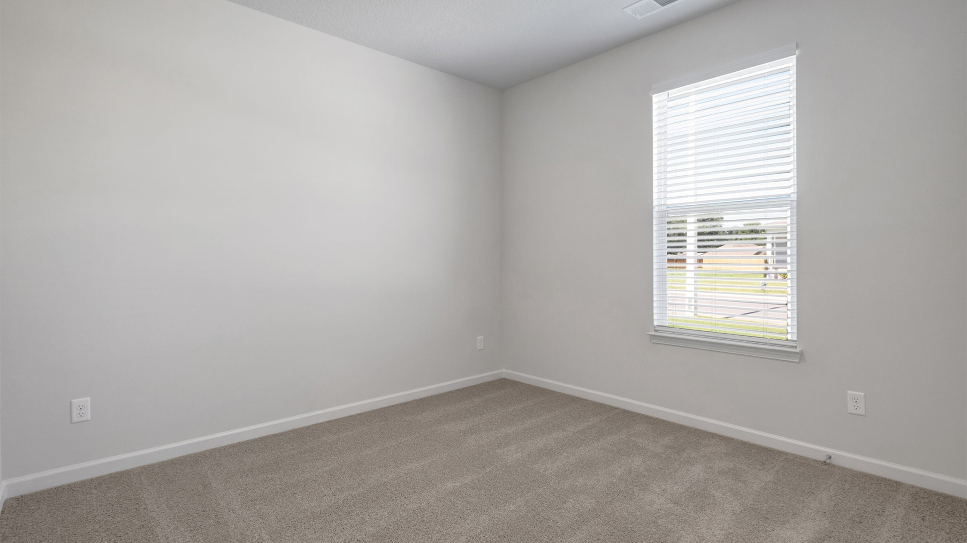 Second bedroom at the front of the home with a window