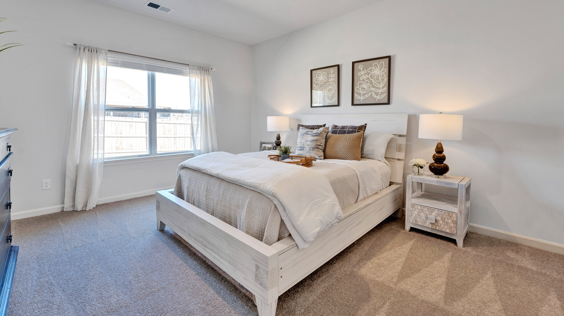 Primary bedroom with a large double window overlooking the backyard