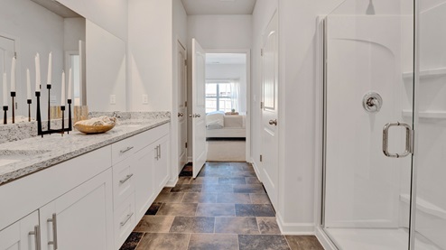 primary bathrooms have large mirrors installed over vanities with granite counters