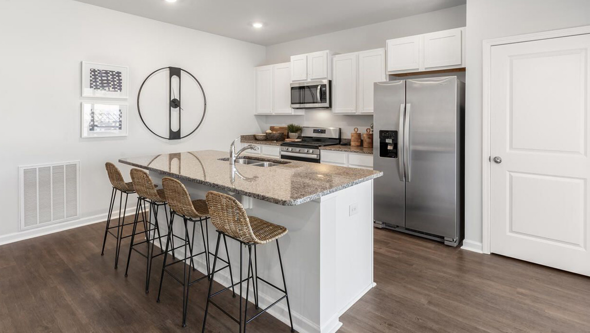 kitchen with granite countertops, cabinets with hardware, stainless steel appliances and bar seating at the island