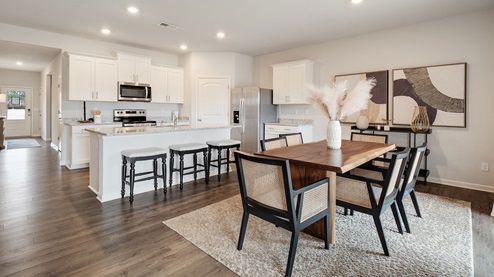 cali plan model in twin lakes community kitchen and dining room with revwood laminate flooring and granite countertops
