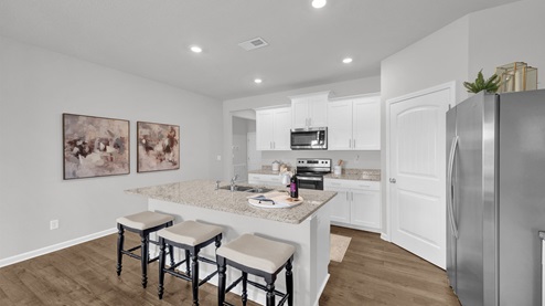 Beautiful kitchen area with light cabinets and stainless steel appliances