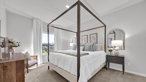 Beautiful primary bedroom with a large double window overlooking the backyard