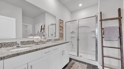 En suite primary bathroom with a glass enclosed walk in shower