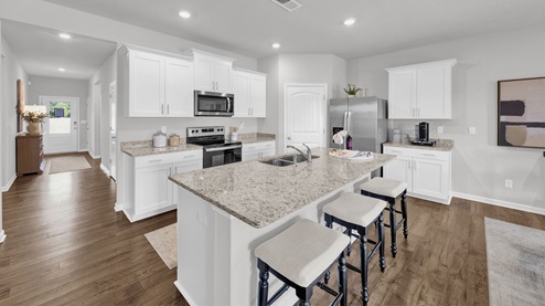 Beautiful kitchen opens up at the end of long entry hall