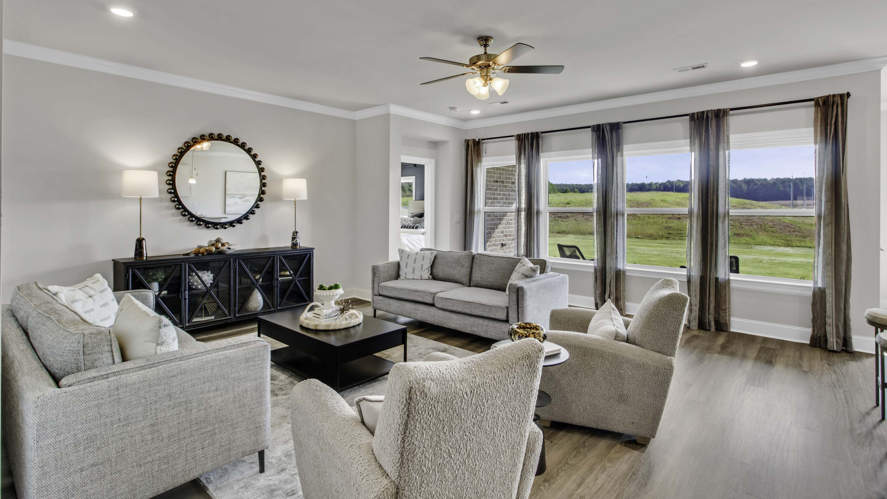 Expansive living room with tall windows overlooking the backyard