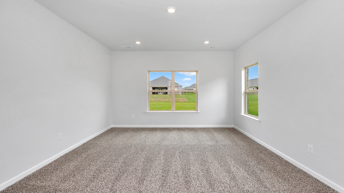 Spacious primary bedroom with carpet flooring and neutral wall paint