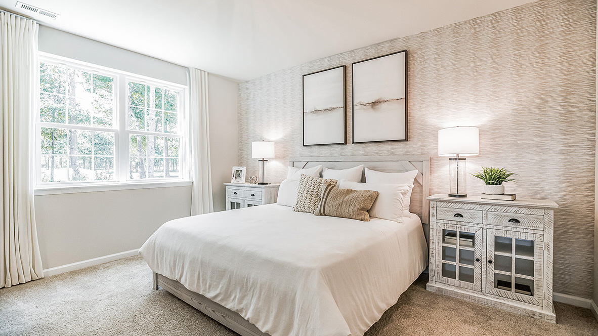 Primary bedroom with a double window overlooking the backyard