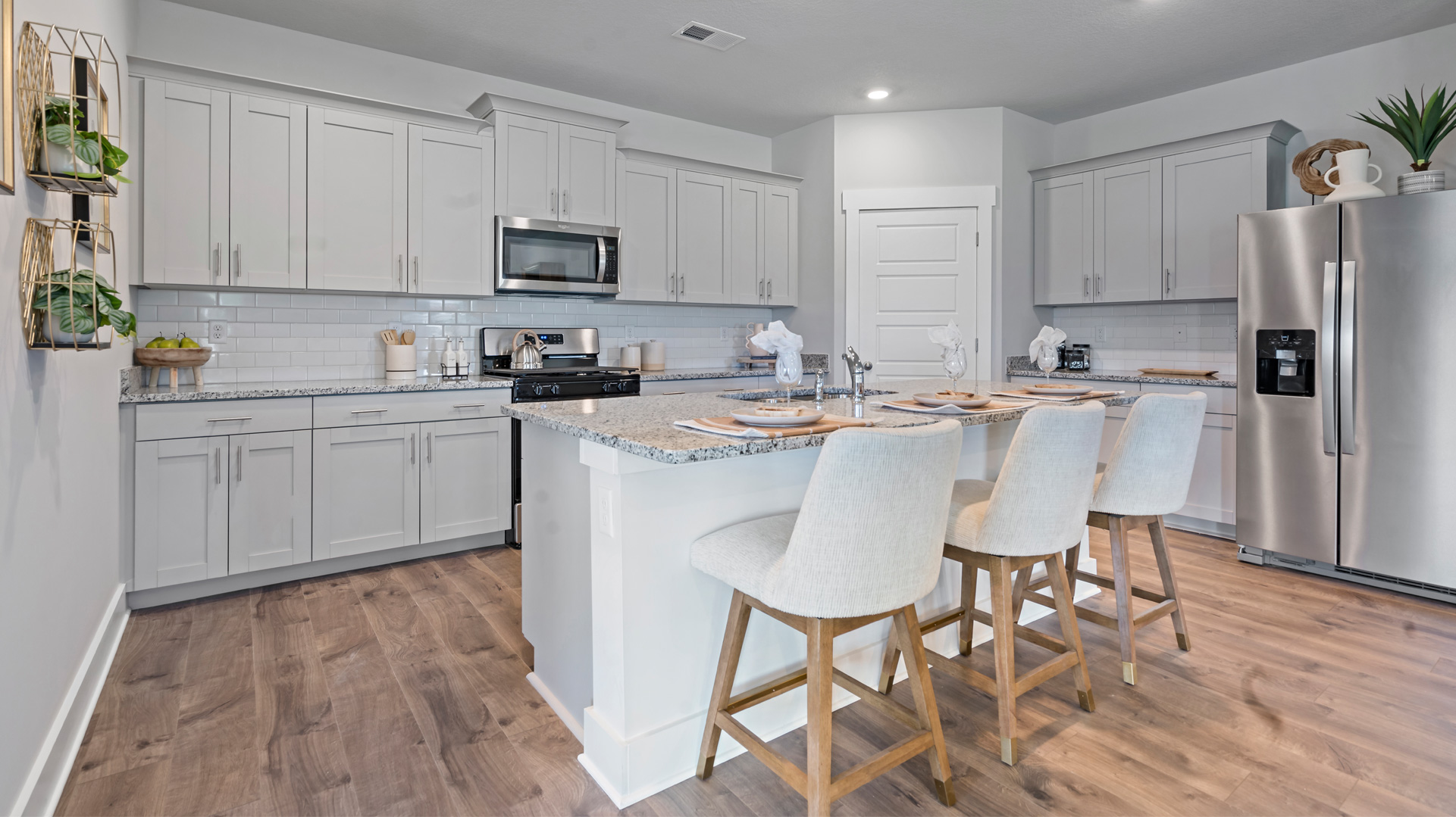 Beautiful kitchen area with light cabinets and stainless steel appliances