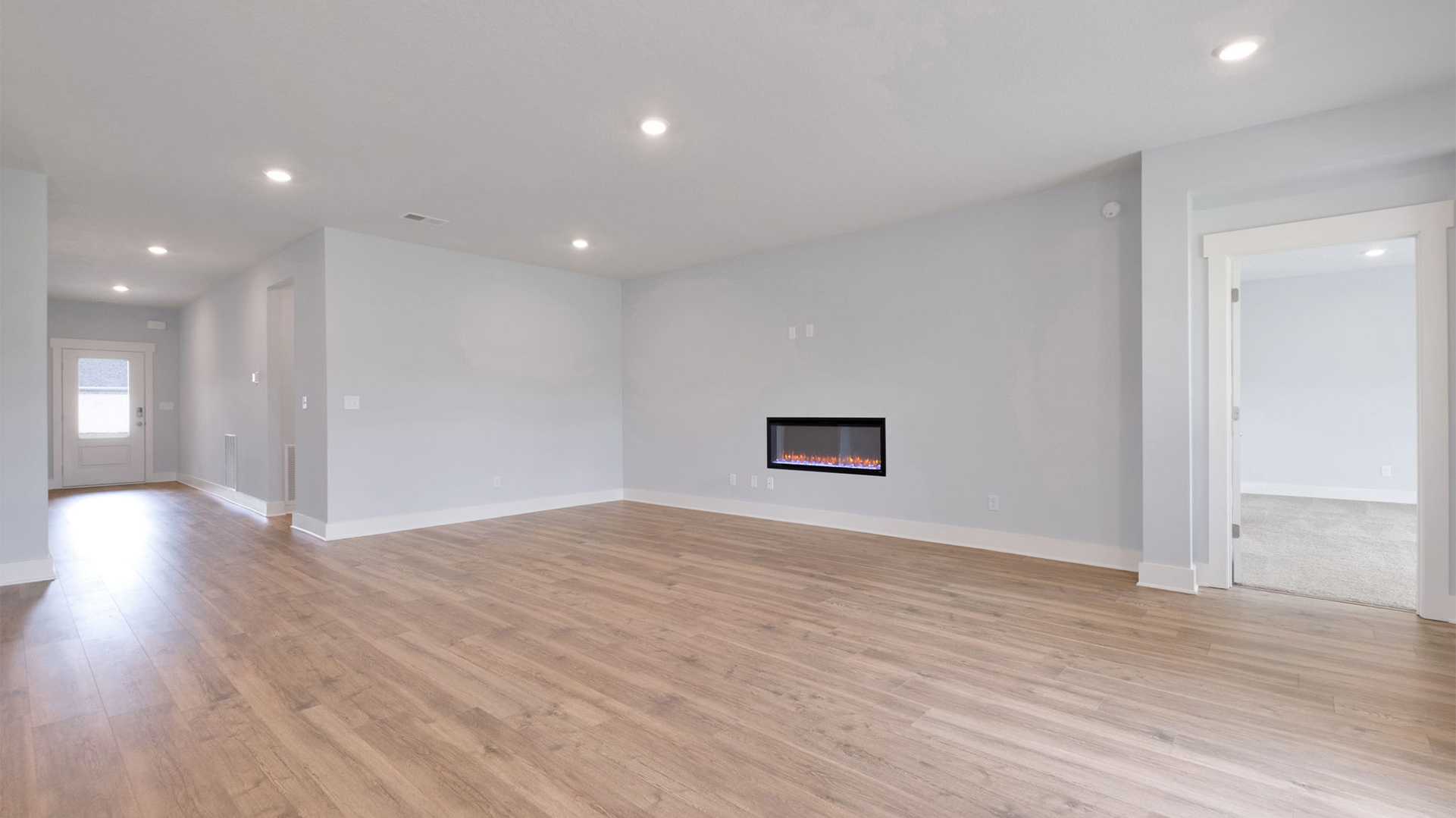 Spacious living room opens up at the end of entry hall