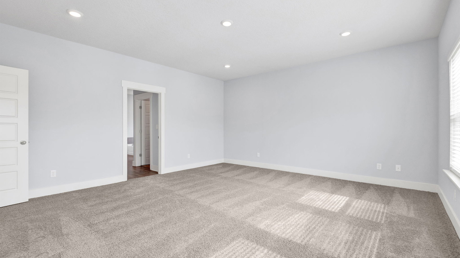 Primary bedroom with carpet floors and recessed lighting