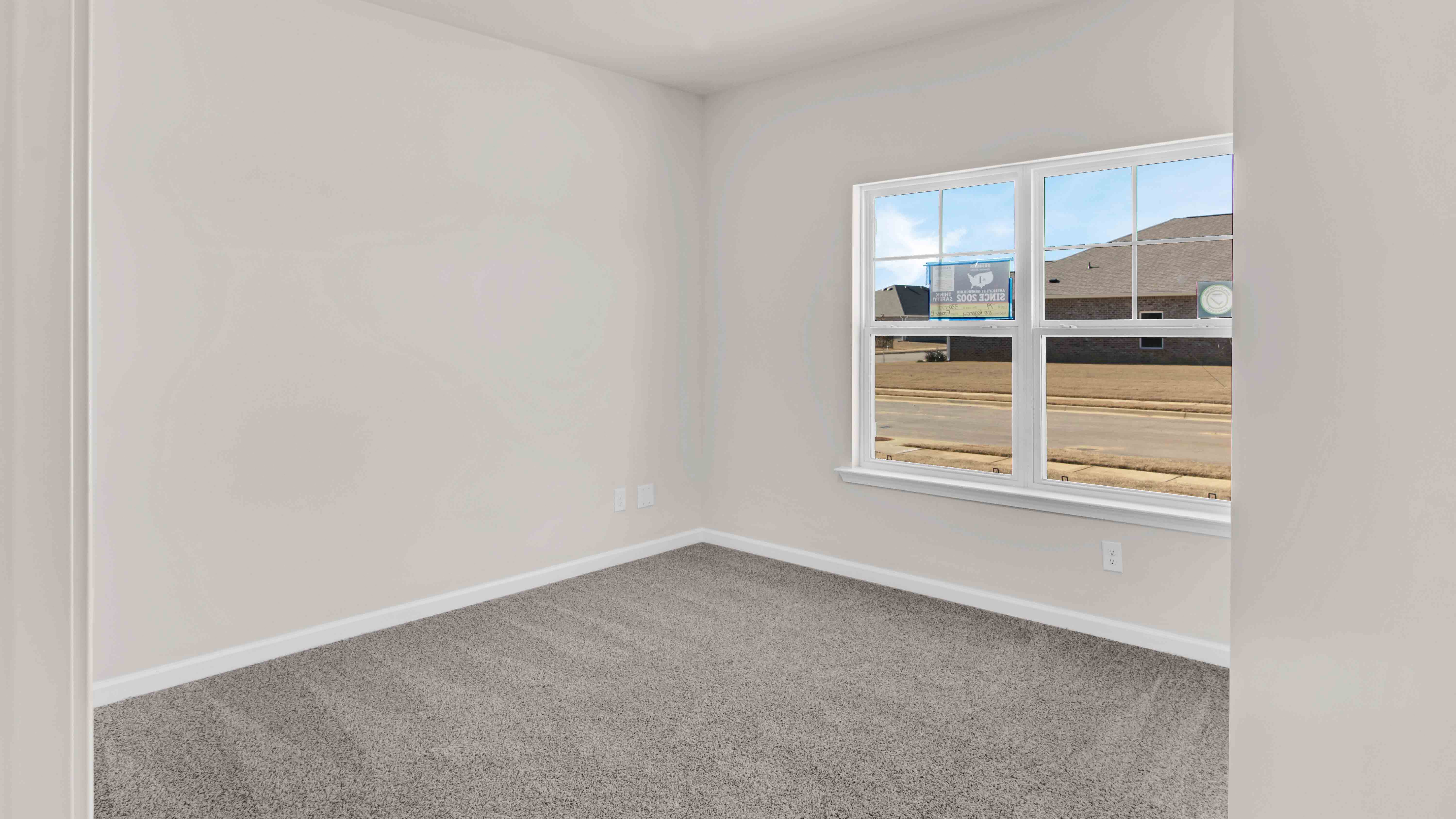 Bedroom two with a large double window overlooking the front yard