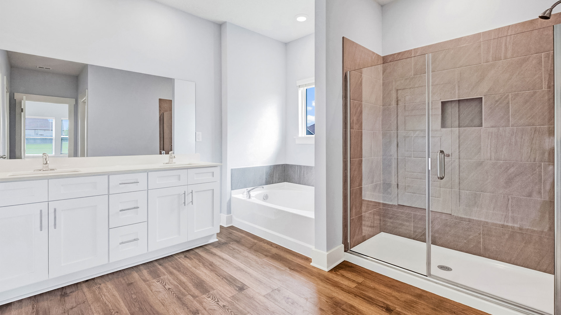 Primary en suite with a dual vanity and a tub and tile surround shower