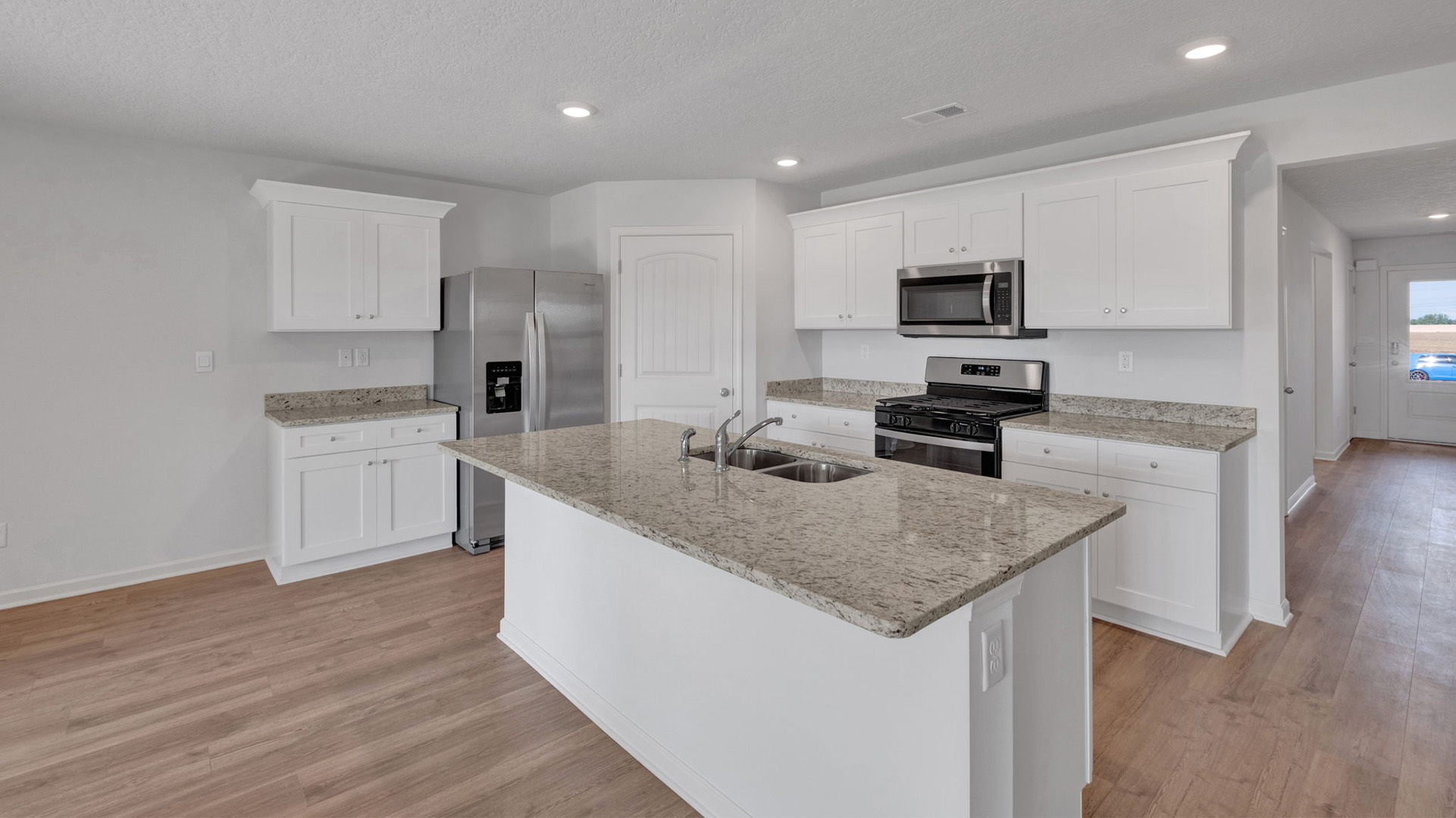 Beautiful kitchen opens up at the end of entry hall