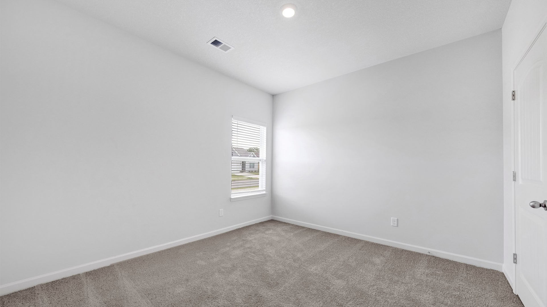 Third bedroom at the front of the home with carpet flooring and neutral paint
