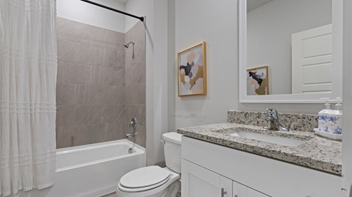 Second bathroom downstairs with a single vanity and an acrylic tub/shower insert