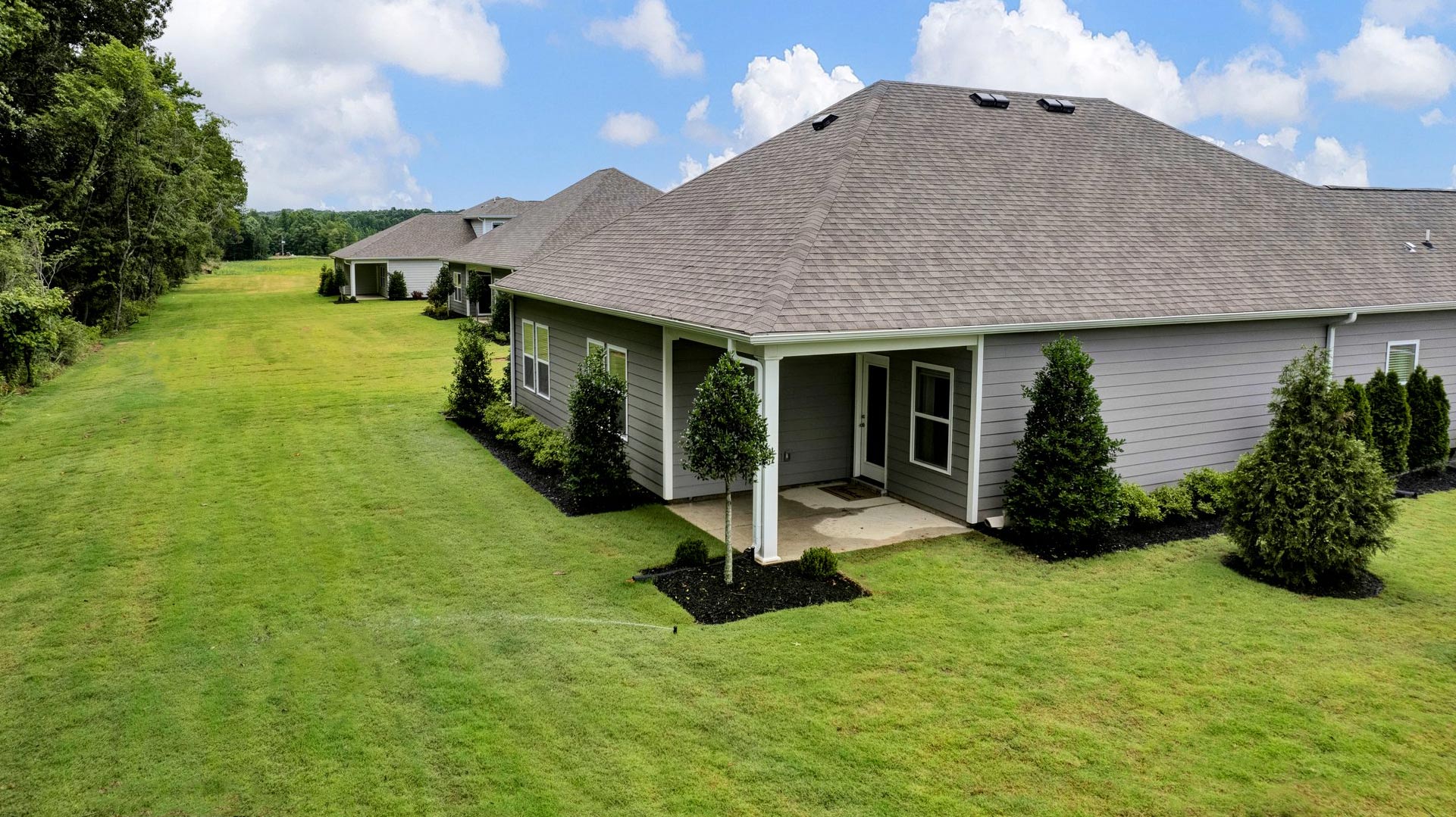 COvered back patio of home overlooking the backyard