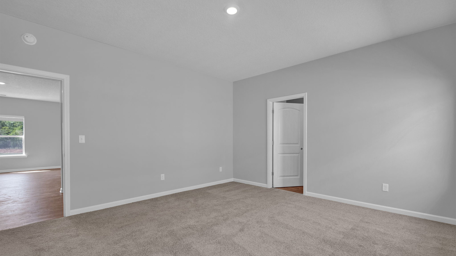 Primary bedroom with carpet flooring and neutral paint