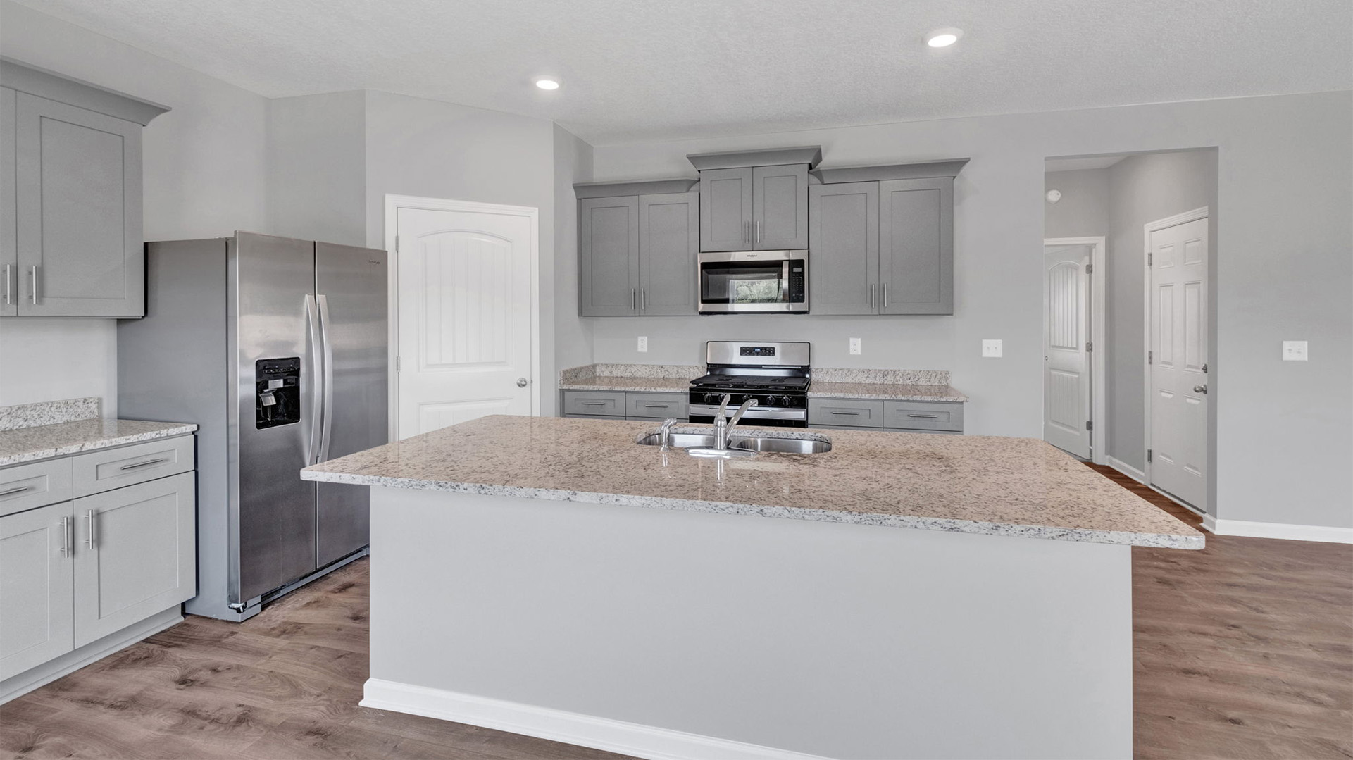 Kitchen area with light cabinets and stainless steel appliances