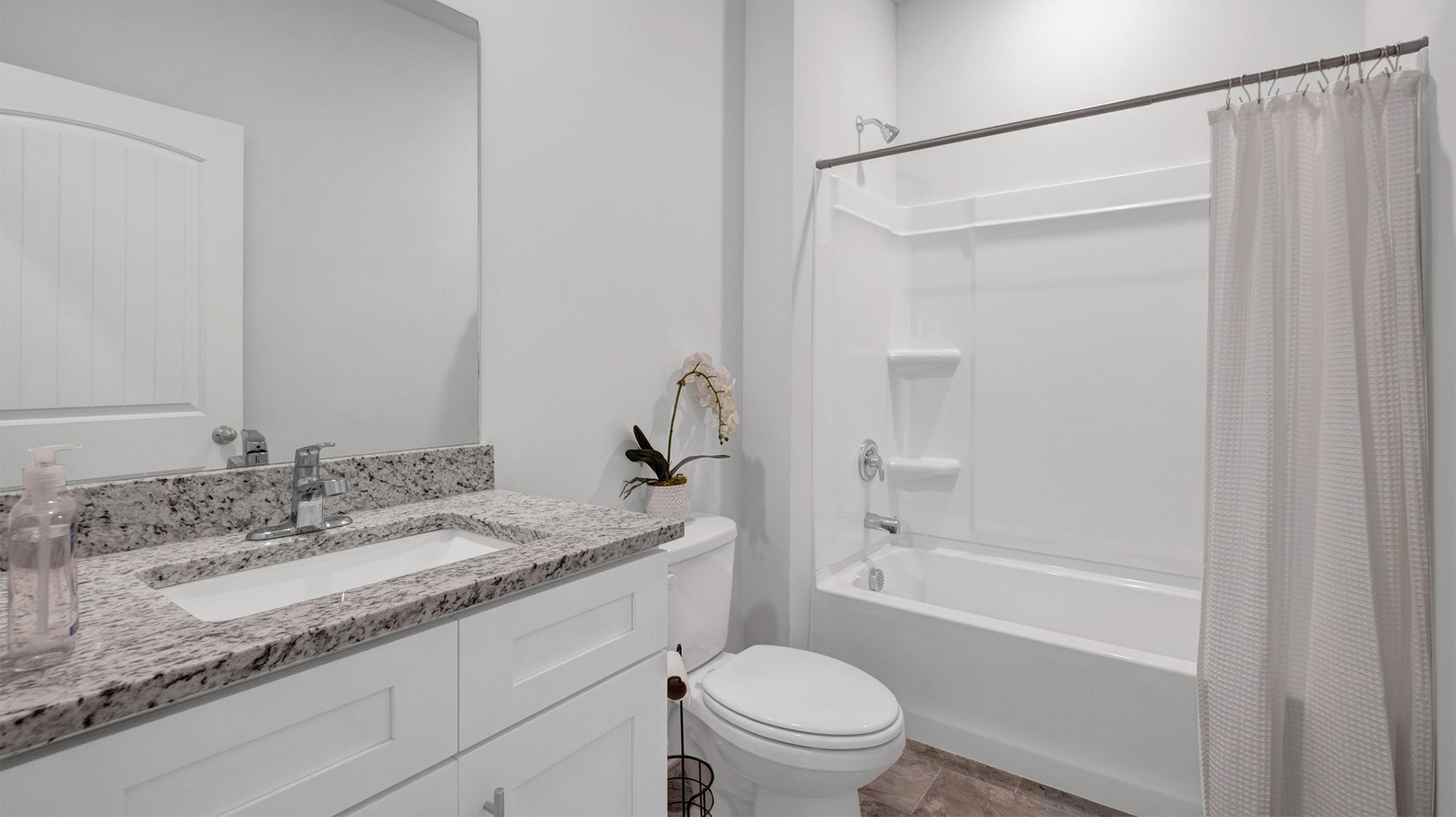 Guest bathroom with a single vanity and an acrlyic tub/shower insert
