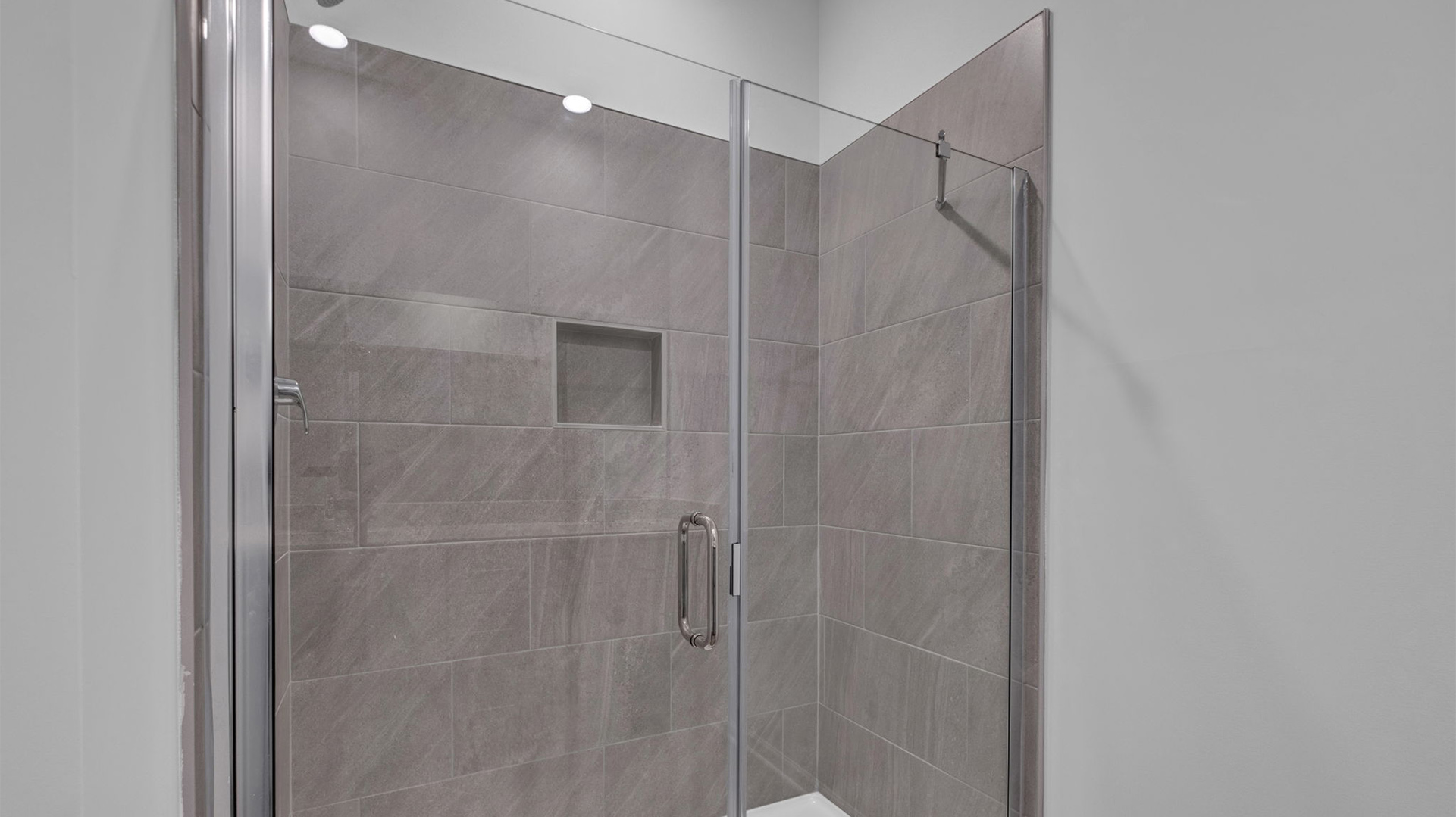 Glass enclosed walk in shower with a tile surround