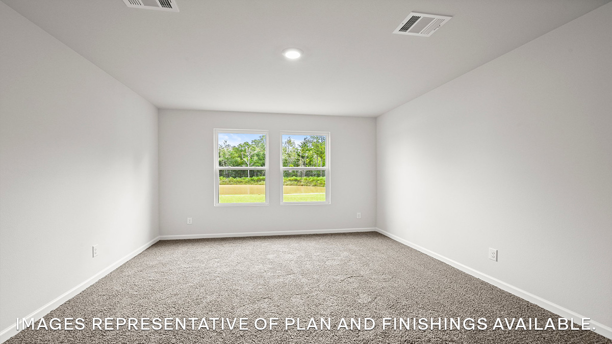 Primary bedroom with a carpet flooring and a large double window for natural light