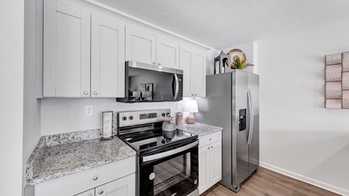 Kitchen area with light cabinets and stainless steel appliances