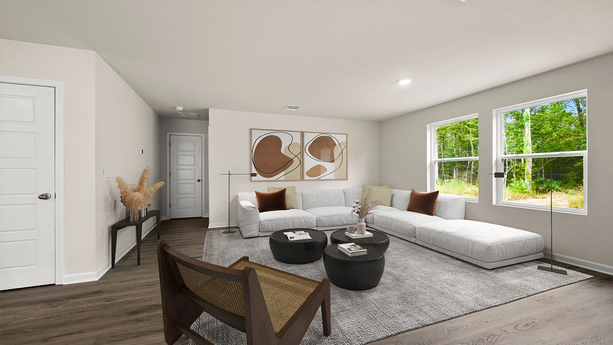 Virtually staged living room with a large double window overlooking the backyard