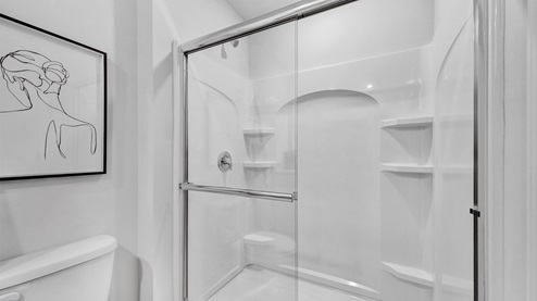 En suite primary bathroom with a glass enclosed walk in shower